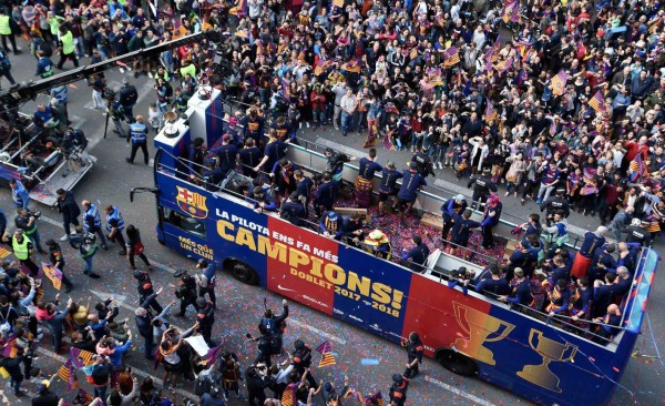 Barcelona's players parade aboard an open-top bus to celebrate their 25th La Liga title in Barcelona on April 30, 2018.Barcelona won their 25th La Liga title after a 4-2 win against Deportivo La Coruna. / AFP PHOTO / LLUIS GENE