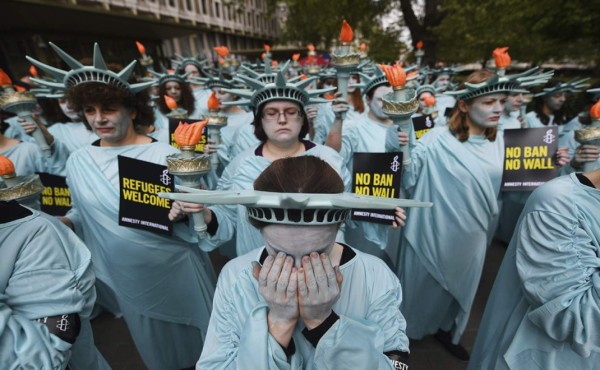 Con trajes de la Estatua de la Libertad, protestan frente a la Embajada de EE.UU. en Londres (Reino Unido). EFE