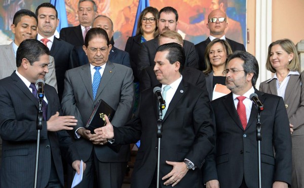 Honduran President Juan Orlando Hernandez (L) approaches to shake hands with Organization of American States (OAS) Secretary for Strengthening Democracy, Francisco Guerrero (C), as the Support Mission Against Corruption and Impunity in Honduras (MACCIH), settles in Tegucigalpa on February 22, 2016. AFP PHOTO / ORLANDO SIERRA