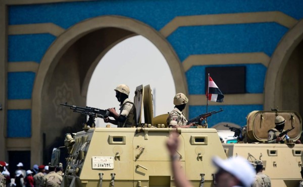 Egyptian soldiers stand guard on armoured personnel carriers, as Christian worshippers leave a stadium where Pope Francis led mass on April 29, 2017 in the Egyptian capital Cairo. / AFP PHOTO / KHALED DESOUKI