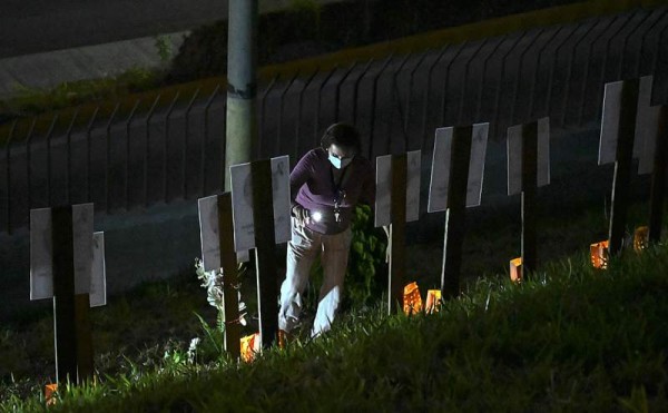 A woman looks at the portraits of the 79 medical doctors and at least 30 nurses, who fought in the first line and were killed by the COVID-19, placed at the yard of the College of Physicians in Tegucigalpa on February 7, 2021. (Photo by Orlando SIERRA / AFP)