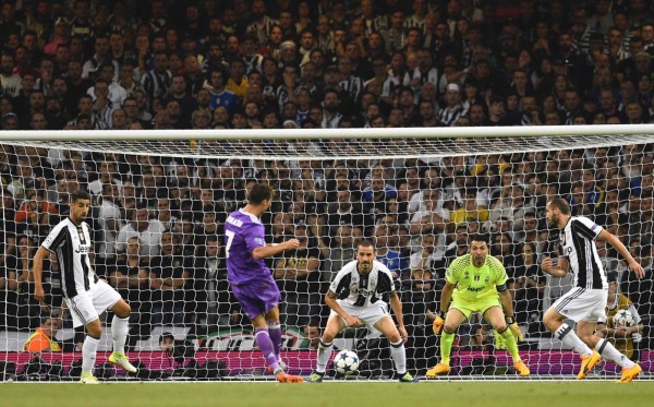Real Madrid's Portuguese striker Cristiano Ronaldo (2nd L) shoots to score the opening goal of the UEFA Champions League final football match between Juventus and Real Madrid at The Principality Stadium in Cardiff, south Wales, on June 3, 2017. / AFP PHOTO / Glyn KIRK