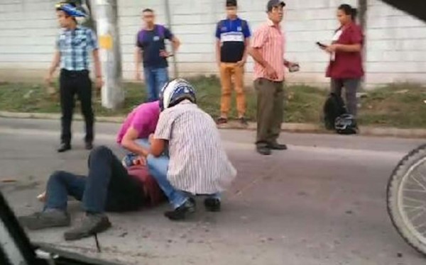 Uno de los motociclistas recibiendo atención por parte de vecinos del sector.