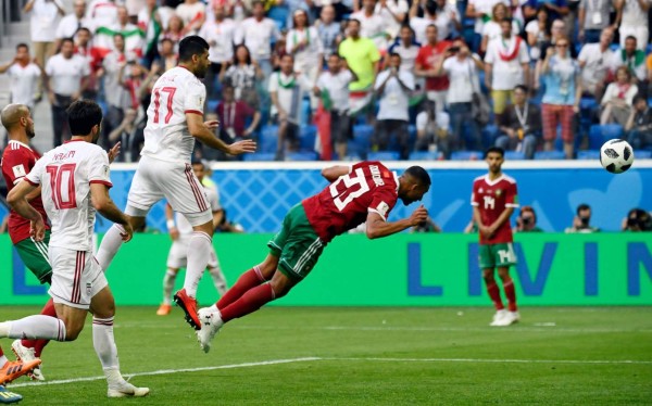 Morocco's forward Aziz Bouhaddouz scores an own goal during the Russia 2018 World Cup Group B football match between Morocco and Iran at the Saint Petersburg Stadium in Saint Petersburg on June 15, 2018. / AFP PHOTO / CHRISTOPHE SIMON / RESTRICTED TO EDITORIAL USE - NO MOBILE PUSH ALERTS/DOWNLOADS