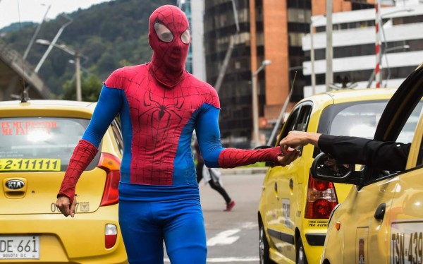 Colombian Jahn Fredy Duque, dressed as superhero 'Spiderman', collects money from drivers after performing on the streets in Bogota, Colombia on April 24, 2017. Duque hangs a white cloth 26 meters long - his 'cobweb - from a bridge near the international center of Bogota, where he performs in the street for a livelihood. / AFP PHOTO / RAUL ARBOLEDA