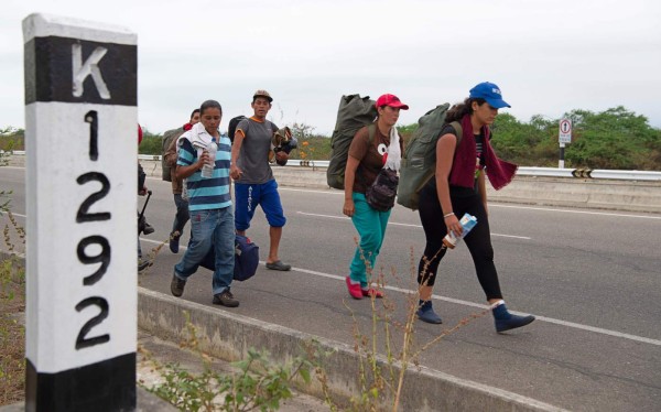 A group of Venezuelan migrants walk southbound along the Pan American highway after receiving their refugee permit at the Peruvian border post at the binational border attention centre (CEBAF) in Tumbes on June 14, 2019. - Some 6,000 Venezuelans have entered to Peru in the last two days, twice of the daily flow, as starting on June 15, 2019, Peru will require a humanitarian visa, in addition to the passport, to all Venezuelan citizens who wish to enter the country alleging security reasons. (Photo by Cris BOURONCLE / AFP)