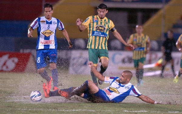 El jugador de Victoria, Leonardo Dominguez, se barre y le quita el balón al goleador del Parrillas One, Juan Josúe Rodríguez.