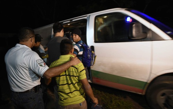 TO GO WITH AFP STORY BY CAROLA SOLEMexican Immigration Service agents detain migrants travelling on a train during an operation to stop illegal Central American migrants in the San Mateo community in Palenque, Chiapas State, Mexico, on June 20, 2015. Hundreds of Central American migrants arrive in Mexico on their way to the United States. AFP PHOTO/ALFREDO ESTRELLA