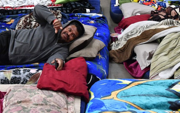 An evacuee looks on from a blow-up bed at the Placer County Fairgrounds evacuation center in Roseville, California on February 13, 2017.Almost 200,000 people were under evacuation orders in northern California Monday after a threat of catastrophic failure at the United States' tallest dam. Officials said the threat had subsided for the moment as water levels at the Oroville Dam, 75 miles (120 kilometers) north of San Francisco, have eased. But people were still being told to stay out of the area. / AFP PHOTO / Josh Edelson