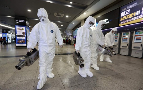 Health workers wearing protective gears spray disinfectant as part of efforts to prevent the spread of a new virus which originated in the Chinese city of Wuhan, at a bus terminal in Gwangju on January 28, 2020. - South Korea will send chartered planes to the Chinese city of Wuhan this week to return hundreds of its citizens to Korea, the foreign ministry said, amid concerns about the spread of the SARS-like virus. (Photo by - / YONHAP / AFP) / - South Korea OUT / REPUBLIC OF KOREA OUT NO ARCHIVES RESTRICTED TO SUBSCRIPTION USE