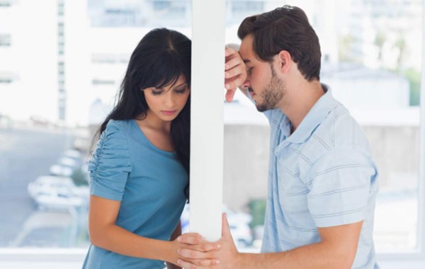 Divided couple are separated by white wall