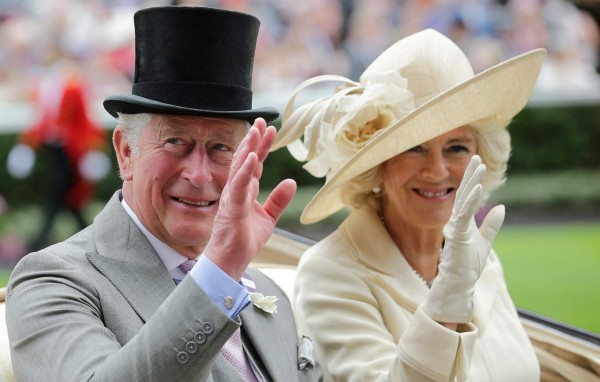 Britain's Prince Charles, Prince of Wales (L) and his wife Britain's Camilla, Duchess of Cornwall wave as they arrive on day one of the Royal Ascot horse racing meet, in Ascot, west of London, on June 19, 2018. The five-day meeting is one of the highlights of the horse racing calendar. Horse racing has been held at the famous Berkshire course since 1711 and tradition is a hallmark of the meeting. Top hats and tails remain compulsory in parts of the course while a daily procession of horse-drawn carriages brings the Queen to the course. / AFP PHOTO / Daniel LEAL-OLIVAS