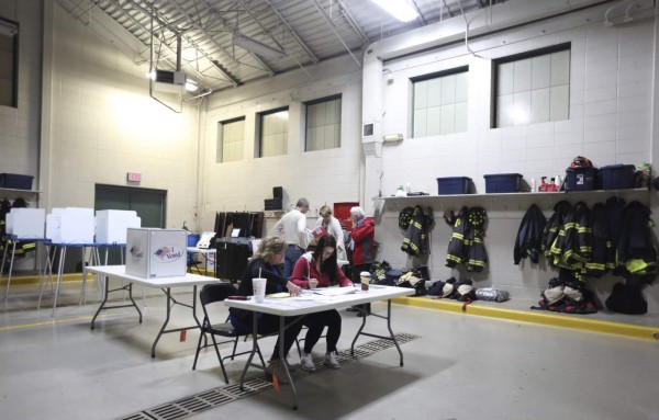 Unos ciudadanos estadounidenses votan en un colegio electoral ubicado en un parque de bomberos durante la jornada de elecciones presidenciales en Estados Unidos. EFE