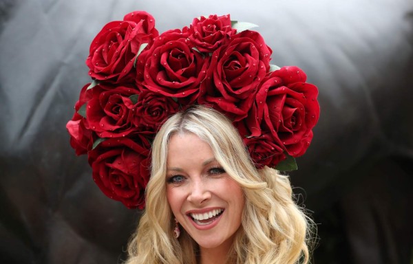 A racegoer poses for a photograph on day one of the Royal Ascot horse racing meet, in Ascot, west of London, on June 19, 2018. The five-day meeting is one of the highlights of the horse racing calendar. Horse racing has been held at the famous Berkshire course since 1711 and tradition is a hallmark of the meeting. Top hats and tails remain compulsory in parts of the course while a daily procession of horse-drawn carriages brings the Queen to the course. / AFP PHOTO / DANIEL LEAL-OLIVAS
