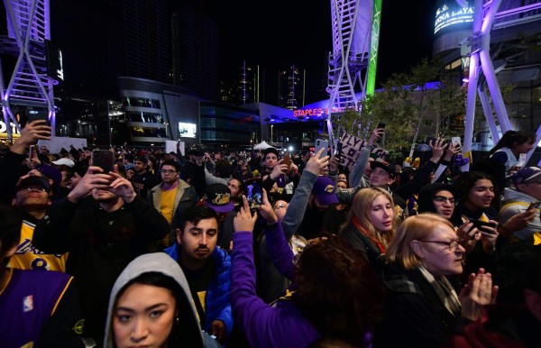 Fans gather to the mourn the death of NBA legend Kobe Bryant, who was killed along with his daughter and seven others in a helicopter crash on January 26, at LA Live plaza in front of Staples Center in Los Angeles on January 27, 2020. - Federal investigators sifted through the wreckage of the helicopter crash that killed basketball legend Kobe Bryant and eight other people, hoping to find clues to what caused the accident that stunned the world. (Photo by Frederic J. BROWN / AFP)
