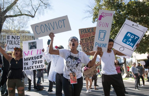 TOPSHOT - Black Lives Matter protesters march through the streets in response to the police shooting of Stephon Clark in Sacramento, California on March 28, 2018. Stephon Clark, an unarmed African American, was shot and killed by police on March 18th at his grandmother's home. / AFP PHOTO / JOSH EDELSON