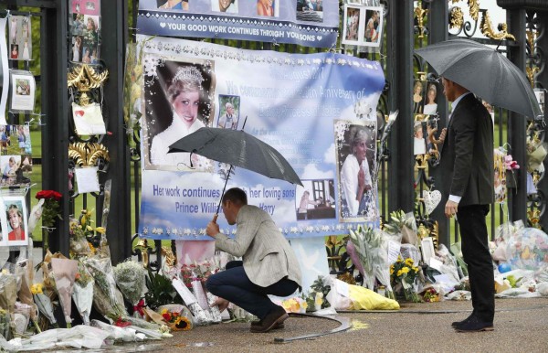 Britain's Prince William, Duke of Cambridge and Britain's Prince Harry look at tributes left by members of the public at one of the entrances of Kensington Palace to mark the coming 20th anniversary of the death of Diana, Princess of Wales, in London on August 30, 2017.Princes William and Harry prepared to pay tribute to their late mother Princess Diana on Wednesday for the 20th anniversary of her death as wellwishers left candles and flowers outside the gates of her former London residence. The Princes visited the Sunken Garden in the grounds of Kensington Palace, which this year has been transformed into a White Garden, dedicated to their late mother, Britain's Diana, Princess of Wales. / AFP PHOTO / POOL / Kirsty Wigglesworth