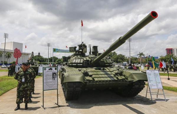 Soldiers of the Nicaraguan army stand guard next to a T-72 Soviet-designed battle tank during the Static Exposition of the Nicaraguan Army, in the framework of the upcoming 38th anniversary, on August 12, 2017 in Managua. / AFP PHOTO / INTI OCON