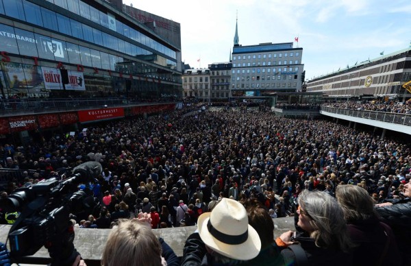 People attend a memorial ceremony on April 9, 2017 at Sergels Torg plaza in Stockholm, Sweden, close to the point where a truck drove into a department store two days before.Four people died and fifteen were injured when a truck plunged into a crowd at a busy pedestrian street in the Swedish capital on April 7, 2017. / AFP PHOTO / Jonathan NACKSTRAND