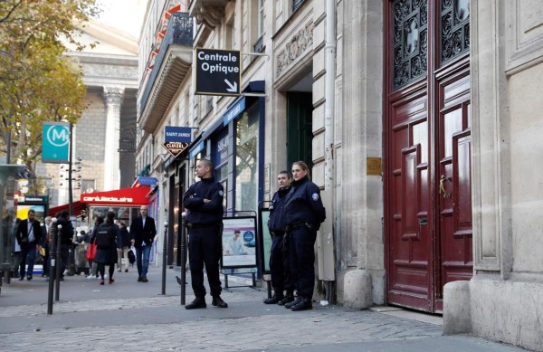 (FILES) This file photo taken at the Rue Tronchet, near Madeleine, central Paris, on October 3, 2016 shows police officers standing guard at the entrance of the hotel residence, where US reality television star Kim Kardashian was robbed at gunpoint by assailants disguised as police who made off with millions, mainly in jewellery.16 people were arrested over Kardashian Paris robbery according police source, AFP reported on January 9, 2017. Kardashian was tied up and robbed of jewellery worth around nine million euros ($9.5 million) when a gang of masked men burst into the luxury Paris residence where she was staying during Fashion Week in October. / AFP PHOTO / Thomas SAMSON