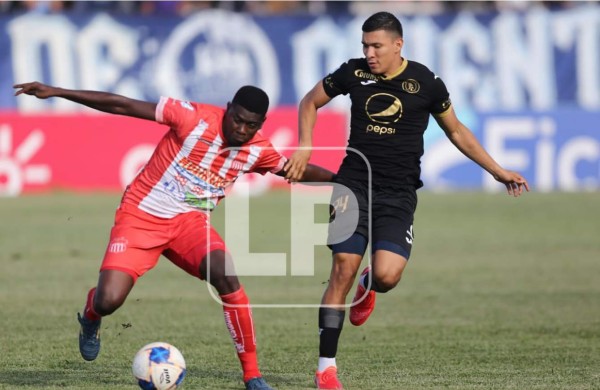 Brayan Barrios del Vida protege el balón ante la marca de Kevin López del Motagua. Foto David Romero