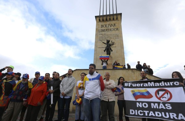 Venezuelan nationals protest against the election of the Constituent Assembly in Venezuela, at the Monument to the Heroes in Bogota, on July 29, 2017.Venezuelan President Nicolas Maduro was pushing forward Saturday with a controversial weekend vote for an assembly to rewrite the constitution, despite growing domestic political opposition, international condemnation and deadly street demonstrations. Neighboring Colombia -- a refuge for tens of thousands of Venezuelans fleeing the chaos at home -- said on Friday it would not recognize the results of Sunday's election in Venezuela. / AFP PHOTO / John Vizcaino