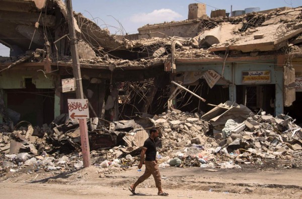 TOPSHOT - A man walks along a damaged street in west Mosul on July 12, 2017, a few days after the government's announcement of the 'liberation' of the embattled city from Islamic State (IS) group fighters. Iraqi Prime Minister Haidar Al-Abadi announced in Mosul earlier in the week that the campaign had ended with the defeat of IS in the city, hailing 'a victory over darkness, a victory over brutality and terrorism'. / AFP PHOTO / FADEL SENNA