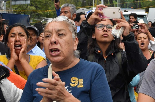 Angry relatives of people trapped in a building which collapsed during the September 19 quake demand the Mexican rescue group called 'Topos' be allowed to join the search efforts, in Mexico City on September 22, 2017 three days after the powerful earthquake hit central Mexico.A powerful 7.1 earthquake shook Mexico City on Tuesday, causing panic among the megalopolis' 20 million inhabitants on the 32nd anniversary of a devastating 1985 quake. / AFP PHOTO / Yuri CORTEZ