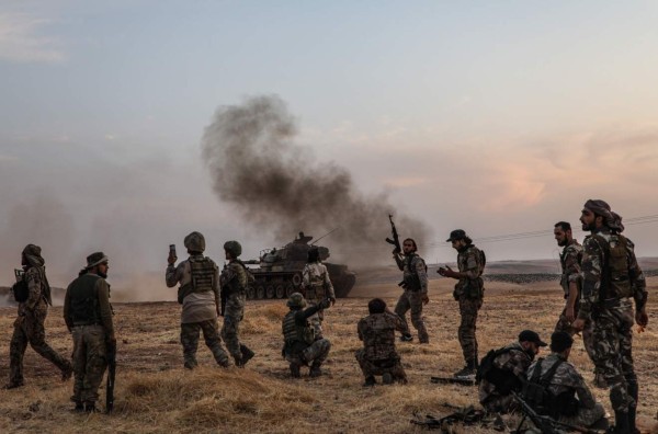 (FILES) In this file photo taken on October 14, 2019 Turkish soldiers and Turkey-backed Syrian fighters gather on the northern outskirts of the Syrian city of Manbij near the Turkish border as Turkey and its allies continue their assault on Kurdish-held border towns in northeastern Syria. - US President Donald Trump on Monday authorized sanctions on Turkey's leaders, reimposed steel tariffs and ended talks on a trade deal, seeking to punish the historic ally for its deadly offensive into Syria. (Photo by Zein Al RIFAI / AFP)