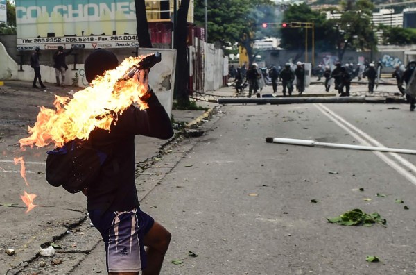 Opposition demonstrators clash with riot police during an anti-government protest in Caracas, on July 20, 2017. A 24-hour nationwide strike got underway in Venezuela Thursday, in a bid by the opposition to increase pressure on beleaguered leftist President Nicolas Maduro following four months of deadly street demonstrations. / AFP PHOTO / RONALDO SCHEMIDT