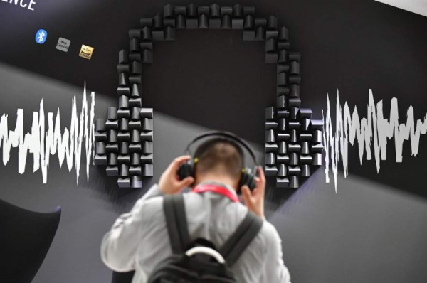 A visitor tests headphones at the Panasonic booth during the IFA, the world's leading trade show for consumer electronics and home appliances, in Berlin on August 30, 2018. / AFP PHOTO / Tobias SCHWARZ