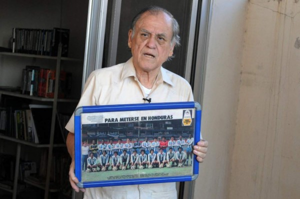 (FILES) In this file photo taken on April 1, 2014 the coach of the Olimpia football club lower divisions Jose de la Paz Herrera Ucles, know as 'Chelato Ucles', shows a picture of the Hondurean team classified to the Spain-1982 FIFA World Cup in Tegucigalpa, Honduras. - Honduran coach Jose de la Paz Herrera, know as 'Chelato Ucles' and who managed to qualify Honduras for its first World Cup in Spain in 1982, died on April 28 in Tegucigalpa. (Photo by Orlando SIERRA / AFP)