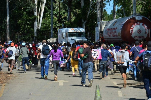 Honduran migrants wait to catch a ride on the roadside in Zacapa departament, Guatemala, on January 17, 2020, on their way to the US. - Mexican President Andres Manuel Lopez Obrador offered 4,000 jobs Friday to migrants in a new caravan currently crossing Central America toward the United States. The caravan, which formed in Honduras this week and is making its way across Guatemala, currently has around 3,000 migrants, Lopez Obrador said. (Photo by Johan ORDONEZ / AFP)