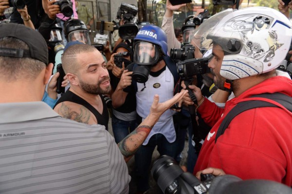 Venezuelan singer Miguel Ignacio Mendoza, 'Nacho' (C), from the Venezuelan pop duo 'Chino & Nacho' talks with the media during a mass protest against President Nicolas Maduro's government in Caracas on April 10, 2017.Venezuela's political crisis intensified last week when the Supreme Court issued rulings curbing the powers of the opposition-controlled legislature. The court reversed the rulings days later, but the opposition intensified its protests from that moment. / AFP PHOTO / FEDERICO PARRA