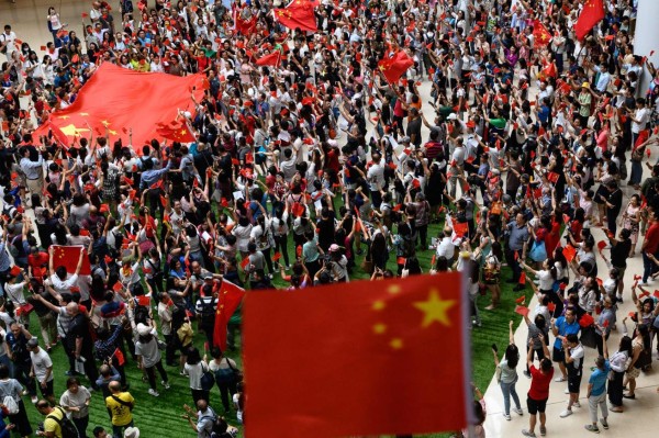 Pro-Beijing protesters display a large Chinese flag as they gather to sing and chant slogans inside a shopping mall in the Tai Kok Tsui district in Hong Kong on September 13, 2019. - The gathering was in response to a defiant protest anthem penned by an anonymous composer which has become the unofficial new soundtrack to Hong Kong's pro-democracy protests, belted out by crowds at flashmobs in malls, on the streets and in the football stands. (Photo by Philip FONG / AFP)