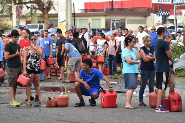 People wait in line to purchase petrol in Arecibo, northwestern Puerto Rico, on September 22, 2017 in the aftermath of Hurricane Maria. Puerto Rico Governor Ricardo Rossello called Maria the most devastating storm in a century after it destroyed the US territory's electricity and telecommunications infrastructure. / AFP PHOTO / HECTOR RETAMAL