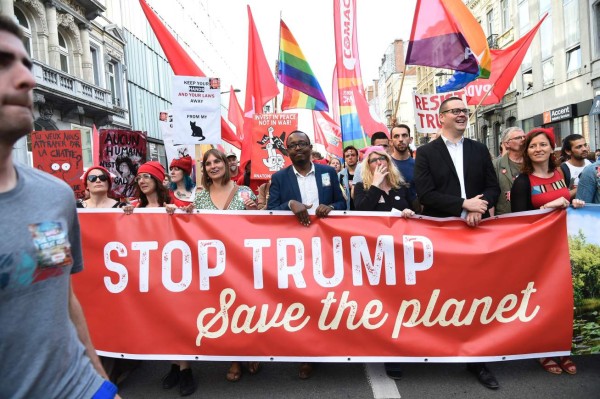 Protesters hold a banner as they take part in a demonstration againt the US president in Brussels on May 24, 2017.US President Donald Trump is on a two-day visit to Belgium, to attend a NATO (North Atlantic Treaty Organization) summit on May 25. / AFP PHOTO / THIERRY CHARLIER