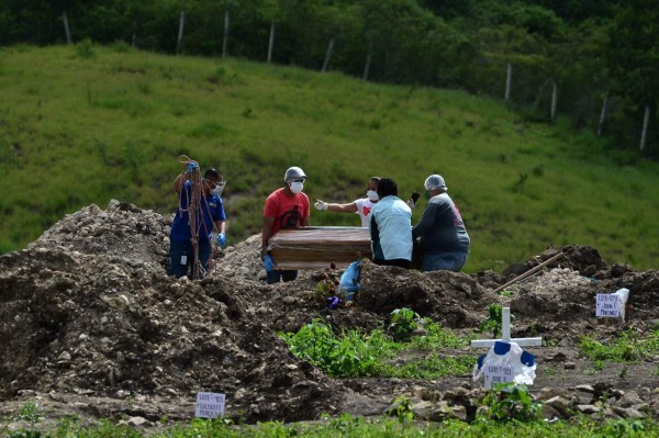 Relatives bury an alleged victim of COVID-19, in an an annex of the Parque Memorial Jardin de los Angeles cemetery, 14 km north of Tegucigalpa, on July 4, 2020. (Photo by ORLANDO SIERRA / AFP)