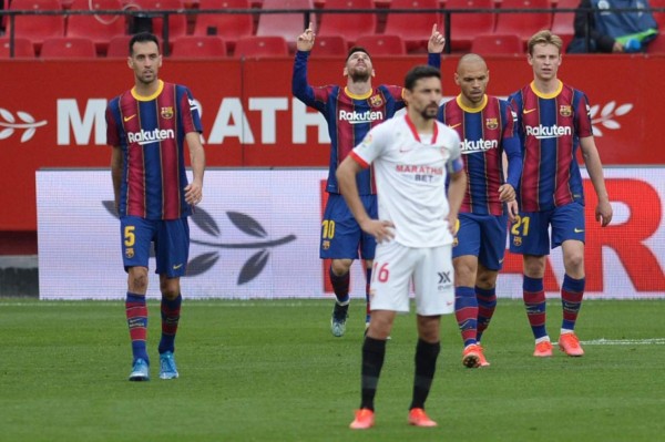 Barcelona's Argentinian forward Lionel Messi (2L) celebtates with teammates after scoring during the Spanish league football match between Sevilla FC and FC Barcelona at the Ramon Sanchez Pizjuan stadium in Seville on February 27, 2021. (Photo by CRISTINA QUICLER / AFP)