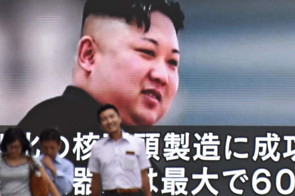 Pedestrians walk past a huge screen in Tokyo on August 9, 2017 displaying news footage of North Korean leader Kim Jong-Un. President Donald Trump issued an apocalyptic warning to North Korea on August 8, saying it faces 'fire and fury' over its missile program, after US media reported Pyongyang has successfully miniaturized a nuclear warhead. / AFP PHOTO / Kazuhiro NOGI