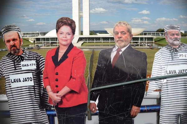 Real size figures of Brazilian President Dilma Rousseff (C-L) and former Brazilian president (2003-2011) Luiz Inacio Lula Da Silva (C-R) with the National Congress in the background are seen during a protest against them in Brasilia on April 11, 2016. An impeachment committee was due to vote Monday on the fate of Brazilian President Dilma Rousseff ahead of a decisive vote in the lower house of Congress on whether she will face trial. / AFP PHOTO / ANDRESSA ANHOLETE