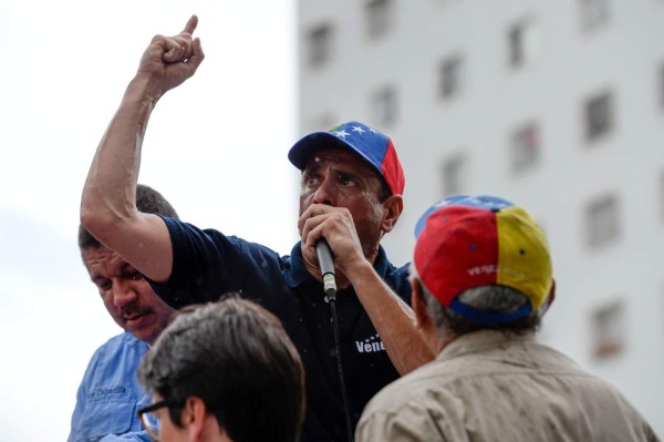 Venezuelan opposition leader and Miranda State governor Henrique Capriles delivers a speech during a demonstration to demand electoral power to activate the recall referendum against President Nicolas Maduro, in Caracas on July 27, 2016.Venezuela's opposition called protests Wednesday to demand electoral authorities allow a referendum on removing Maduro from power, a day after the government moved to outlaw the coalition. / AFP PHOTO / FEDERICO PARRA