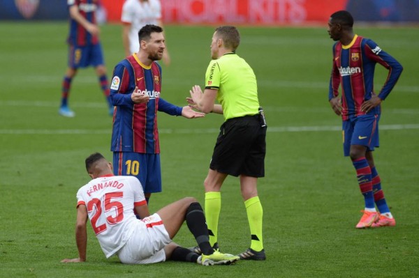 Barcelona's Argentinian forward Lionel Messi (2L) talks to Spanish referee Alejandro Hernandez during the Spanish league football match between Sevilla FC and FC Barcelona at the Ramon Sanchez Pizjuan stadium in Seville on February 27, 2021. (Photo by CRISTINA QUICLER / AFP)