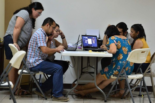 Mexican and Argentinian experts work with the Committee of Relatives of Disapperead Migrants of the Center of Honduras (COFAMICENH), in La Paz, 80 km north of Tegucigalpa,on June 16, 2019. - With the help of Argentinian forensic anthropologists, relatives of disappeared Honduran migrants search for them in the migratory route towards the US. (Photo by ORLANDO SIERRA / AFP)