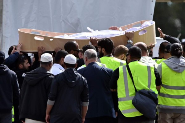 Mourners carry the coffin of a victim killed in the March 15 twin mosque massacre during a funeral at the Memorial Park cemetery in Christchurch on March 20, 2019. - Hundreds of mourners gathered in a Christchurch cemetery on March 20 for the first funerals of those killed in the twin mosque massacre as New Zealanders braced for days of emotional farewells following the mass slayings. (Photo by Anthony WALLACE / AFP)