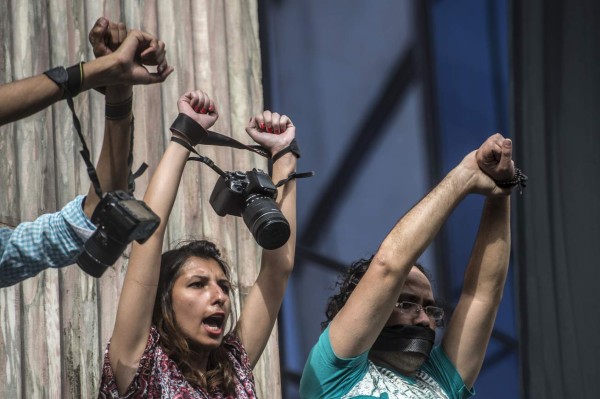 Egyptian photojournalists raise their cameras during a demonstration outside the Syndicate headquarters in Cairo on May 3, 2016 on the occasion of World Press Freedom day, a day after police stormed the headquarters of the journalists' association and arrested two journalists. Egyptian authorities on May 2 ordered the detention of two journalists for 15 days after their arrest on allegations of incitement to protest, a judicial source said. The decision comes a day after police stormed the headquarters of the journalists' association in central Cairo and arrested Amr Badr and Mahmud el-Sakka. A judicial source on Sunday said the pair had been wanted for alleged incitement to protest in violation of the law. / AFP PHOTO / KHALED DESOUKI