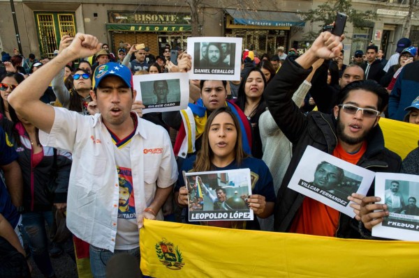 Venezuelans living in Santiago protest against the Venezuelan presidential election and demand the release of political prisoners, at Paseo Bulnes, in front of the La Moneda presidential palace in the Chilean capital on May 20, 2018. Venezuela holds presidential elections today, boycotted by the opposition, in which current president Nicolas Maduro is expected to be easily reelected for a second six-year term of office. / AFP PHOTO / Martin BERNETTI