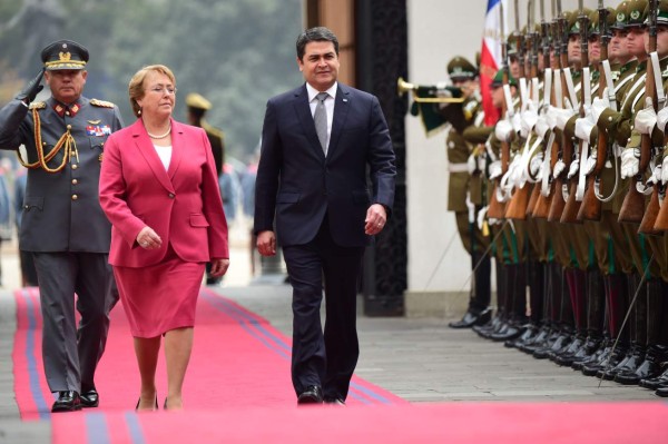 Chilean President Michelle Bachelet (L) and her Honduran counterpart Juan Orlando Hernandez receive military honors upon the latter's arrival at La Moneda presidential palace in Santiago on May 28, 2015. AFP PHOTO/MARTIN BERNETTI