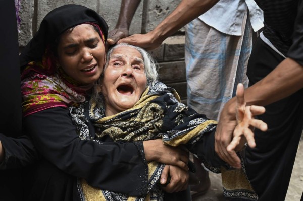 Relatives of victims mourn after a fire tore through apartment blocks mourn in Bangladesh's capital Dhaka on February 21, 2019. - At least 70 people were killed when fire tore through crumbling apartment blocks in a historic part of Dhaka, setting off a chain of explosions and a wall of flames down nearby streets, officials said on February 21. It started in one building where chemicals for deodorants and other household uses were illegally stored and spread at lightning speed to four nearby buildings, the fire service said. (Photo by MUNIR UZ ZAMAN / AFP)
