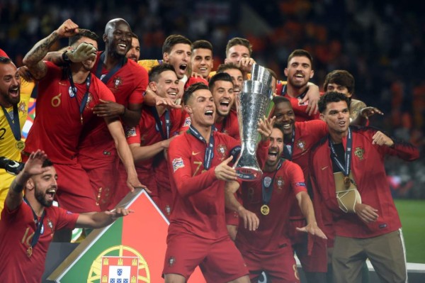 Portugal's forward Cristiano Ronaldo raises the trophy as he celebrates with teammates winning the UEFA Nations League final football match between Portugal and The Netherlands at the Dragao Stadium in Porto on June 9, 2019. (Photo by PATRICIA DE MELO MOREIRA / AFP)